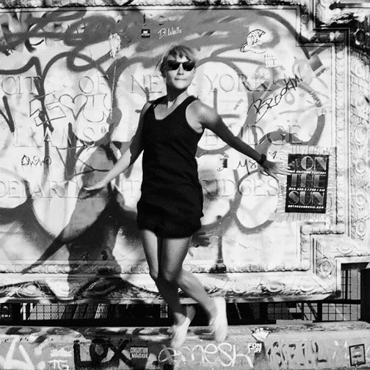 Liz Tan standing in front of a graffiti wall